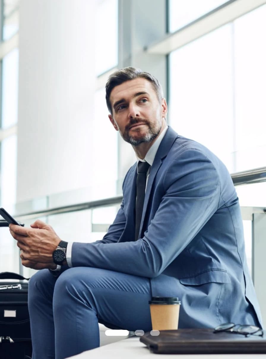 A dental professional reviewing a drtalk discussion on a phone in a bright office foyer
